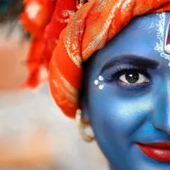 A close-up, artistic portrait of a person in Krishna makeup, focusing on the eye and intricate details of the costume. This is great for cultural and festival photography.