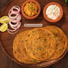 Our Masala Chapathi is a spiced whole wheat flatbread, served here with raita and a vegetable side dish. It's a flavorful alternative to plain roti.