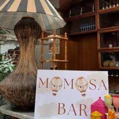 A custom 'Momosa Bar' sign designed for the hot air balloon themed baby shower, adding a playful and personalized touch for the guests.