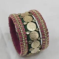 A classic bridal combination of bottle green and ruby pink silk thread. This bangle set is adorned with temple coins and Kundan stones, making it a timeless choice for wedding ceremonies.