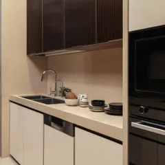 Styling turns the everyday into a curated moment. A touch of greenery, a bowl of fresh fruit, and perfectly stacked ceramics on the countertop add life and personality to this modern kitchen.