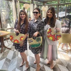 Three happy guests showing off the beautiful straw bags they painted themselves. At my parties, everyone leaves with a unique, handmade party favor that they can actually use and cherish.