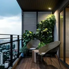 A minimalist balcony design with a stunning city view. The space is furnished with modern wicker chairs and a small table, perfect for enjoying a quiet evening outdoors.