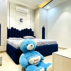 A cozy and playful bedroom we completed for a young client. The centerpiece is the custom-made bed with a deep blue, scalloped upholstered headboard that extends to the matching wardrobe doors, creating a cohesive and fun design.
