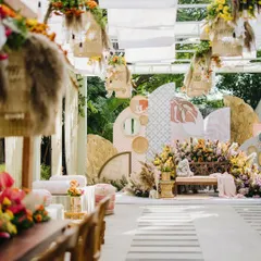 The bride's seating area is the heart of the Mehendi, featuring a beautiful backdrop of abstract boho shapes and prints. The space is surrounded by vibrant, colourful flowers and pampas grass, making it the perfect spot for photos.