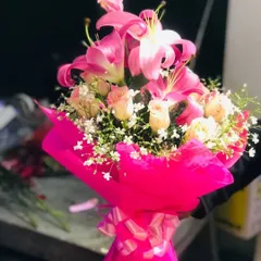 A vibrant bouquet combining bright pink lilies and soft roses, wrapped in matching pink paper. This is a very popular choice for birthdays and anniversaries.