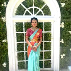 A full length photo of Rashmitha's traditional look. The makeup is fresh and bright, perfect for a daytime wedding event.
