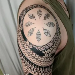 A close-up of the shoulder portion of a freehand Maori sleeve. The design features traditional motifs that symbolize protection, family, and personal achievements, all custom-drawn for the client.