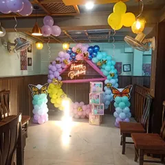 A butterfly-themed decoration set up in a restaurant space. I can work with any venue to create a beautiful party corner, complete with a balloon arch and light-up props.