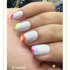 A bright and cheerful design with a clean white base and colorful, minimalist flower petals painted along the cuticles for a unique floral look.
