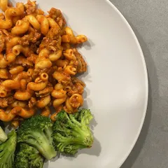 Yes, I eat pasta, and you can too. This is a comforting plate of macaroni in a rich sauce, balanced with a side of steamed broccoli for added fiber and nutrients. It's all about incorporating the foods you love into a healthy lifestyle.