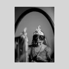 A moment of quiet reflection. This black and white portrait of Bhawana captures her getting ready, focusing on the intricate details of her 'mukut' and her gentle expression. Monochrome adds a timeless, classic feel to bridal photography.