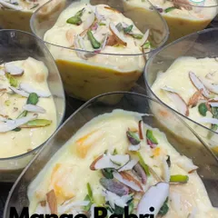 My seasonal Mango Rabri is a delightful fusion dessert. It's a traditional, creamy Indian rabri infused with fresh mango pulp and garnished with sliced almonds and pistachios.