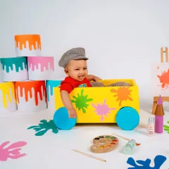 A splash of color for this little artist! This vibrant painter-themed milestone shoot is full of fun props like a colorful cart, paint buckets, and an easel, perfect for a creative baby.