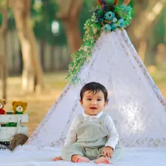 Before the cake smash begins, we capture beautiful portraits of your one year old. This outdoor session features a lovely lace teepee and rustic props for a charming photo.