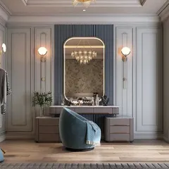 This luxurious dressing area features a custom vanity with ample storage and a large, beautifully lit mirror. We used classic wall molding and elegant light fixtures to create a sophisticated, Parisian-inspired space.
