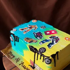 A 2kg Transformers themed cake designed to look like a book. This chocolate truffle cake is decorated with various Autobot and Decepticon toppers.