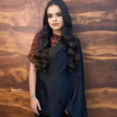 A full portrait exuding confidence. The combination of a classic black saree, bold makeup, and perfectly styled waves is a powerful statement for any evening event.