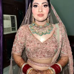 A close-up of the pastel bride's look. The peachy warm tones and nude lipstick create a soft, elegant finish that complements her mint green jewelry perfectly.