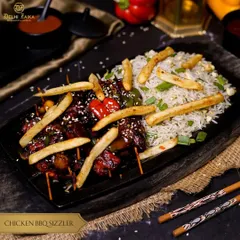 Savor the smoky goodness of our Chicken BBQ Sizzler. Juicy chicken skewers glazed with a zesty BBQ sauce are served on a sizzling bed of rice.