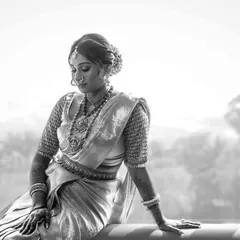 A pensive bridal portrait in black and white. The natural light from the window beautifully sculpts her features and highlights the texture of her traditional saree.