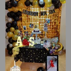 A classic "Bride to be" decor setup perfect for a bridal shower at home. We used a gold foil curtain, balloons, and light-up initials to create a festive and photo-ready corner for the celebration.