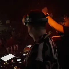 A close-up moment during a collaborative set. The focus and communication between DJs are key to a successful B2B performance.