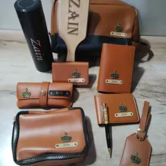 A close-up of the personalized leatherette accessories for actor Zain Imam. Each piece is customized with his name and a crown charm.