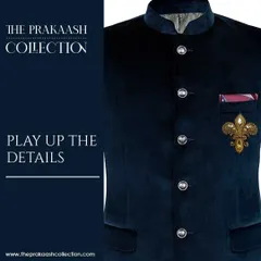 A close-up of a navy velvet bandhgala jacket, where the details are played up with a gold fleur-de-lis patch. This is a perfect example of giving a modern twist to a regal ensemble.