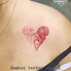 A unique red ink tattoo of a heart with a marbled, liquid effect.