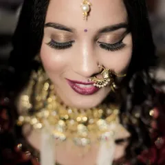 A delicate close-up focusing on the bride's stunning eye makeup and jewelry. This shot highlights the artistry of her bridal look, from her long lashes to her shimmering eyeshadow.
