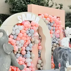 A close-up of the balloon-filled archway, showcasing the soft color palette of pink, grey, and beige that defined this chic and modern jungle theme.