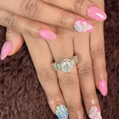 A bold and beautiful set with bright pink nails, full-coverage blue crystal accent nails, and 3D flowers.