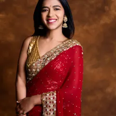 Looking like she stepped out of a painting, our client is a dream in this beautiful maroon georgette saree with a heavy gold border and a sequined blouse.