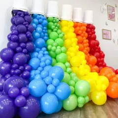 A creative and artistic balloon installation designed to look like rainbow-colored paint spilling from buckets. This type of unique sculpture is perfect for creative industry events or brand activations.