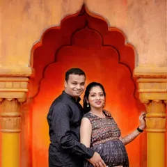 We use architectural elements to create stunning portraits. This couple is framed by a traditional Indian-style archway with warm, glowing light, blending modern attire with classic design.
