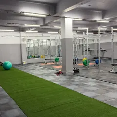 An integrated training environment with a turf track running alongside the main gym floor. This allows us to combine strength exercises with speed and agility drills, creating a comprehensive athletic development session.