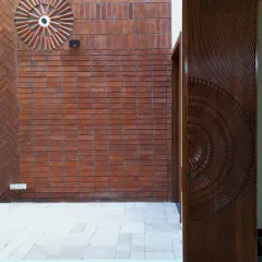 Craftsmanship is at the heart of my work. This view into a central courtyard showcases a beautifully detailed brick feature wall alongside a custom-carved wooden door, creating a rich texture and a personal touch that you can appreciate every day.