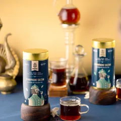 A sophisticated shot of Hindraj's Champagne Sultan black tea. The deep blue background and elegant glassware give this image a premium, almost majestic feel, perfect for a luxury tea brand.