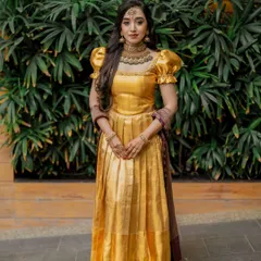 A portrait of the client in her golden gown. The makeup features a defined eye and a neutral lip, creating a sophisticated and timeless look.
