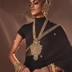 An ethereal shot for Reasons Jewellery, where the model is adorned in multiple layers of bespoke pieces, including necklaces, bangles, and a headpiece, showcasing the brand's opulent style.