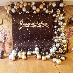 A stunning "Congratulations" backdrop with a starry night theme and a black, gold, and silver balloon frame, perfect for any major achievement.