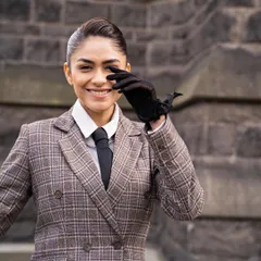 A close-up of the androgynous look, showing the slicked-back hair and black gloves that added to the polished, powerful vibe.