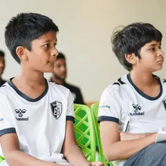 Our players listen intently during a classroom session at the camp, learning about the tactical and mental aspects of the game from seasoned professionals.