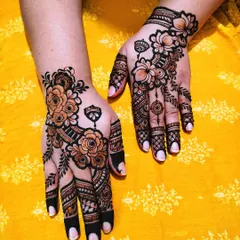 A matching set of Arabic floral mehndi on both hands. The design is asymmetrical but balanced, with a focus on bold flower outlines and delicate vine work.
