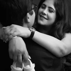 It's all in the little details. This close-up on the tiny baby shoes and the couple's loving embrace creates a deeply sentimental and timeless black and white portrait.