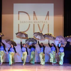 A glimpse from our 'City of Stars' showcase, where my students owned the stage. I love incorporating props like these umbrellas to add a unique visual flair to a group dance, creating a truly memorable sangeet performance.