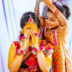 A heartwarming moment as a young family member joins in to shower the bride with flowers and water.