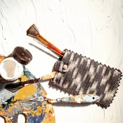 Our crochet utility pouch is incredibly versatile. Here, it's being used to hold art supplies like brushes and palette knives, keeping them organized and protected.