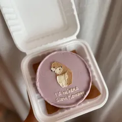 A sweet bento cake for a mom-to-be. This design features a hand-drawn bear with the message "I'll be here soon Mommy" on a lavender-colored buttercream base.